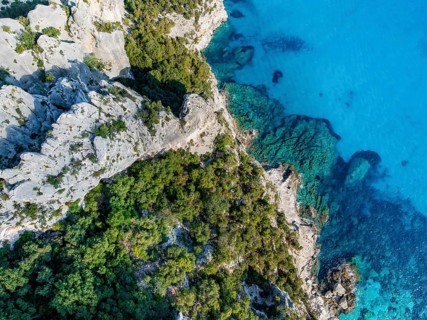 Picturesque rocky coast, blue sea at Cala Goloritzé, top-down, aerial view, Golfo di Orosei,