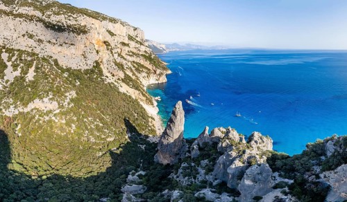 Picturesque rocky coast, cliffs with L'Aguglia pinnacle, blue sea and Cala Goloritzé beach, aerial