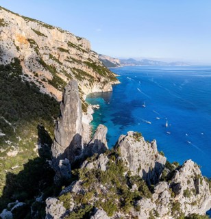 Picturesque rocky coast, cliffs with L'Aguglia pinnacle, blue sea and Cala Goloritzé beach, aerial