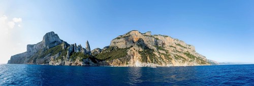Panorama, picturesque rocky coast, cliffs with caves in the morning light, L'Aguglia rock peak,