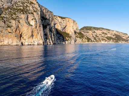 Motorboat rides on picturesque rocky coast ImmorgenLicht, cliffs, Golfo di Orosei, Baunei,