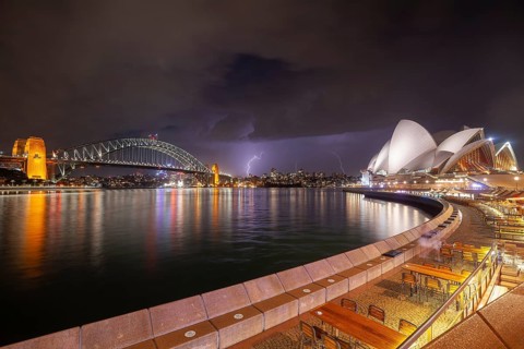 The Sydney Opera and Bridge in the dark and approaching thunderstorm, spectacular lightning over