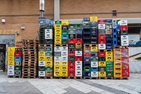 Empty beverage crates, from various manufacturers, bottling, types, stacked at a restaurant, for