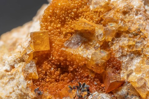 Shiny crystals of blue and orange color can be seen in this mineral formation. They are sparkling