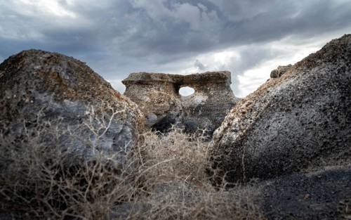 Eroded rock formations with rock tunnels, volcanic landscape with dramatic cloudy skies, Ciudad