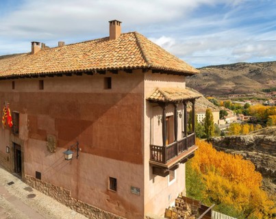 Alberque hostel building with flags flying, historic buildings in medieval village of Albarracín,