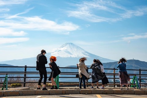 Tourists enjoy the view and take pictures, view of the snow-covered summit of Mount Fuji volcano in