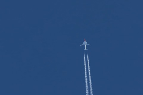 Boeing 737 jet passenger aircraft of Norwegian Air airlines flying in a blue sky with contrails or
