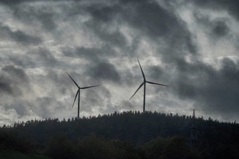 Wind turbines in pine forest during thunderstorm, Bavarian Forest, Bavaria, Germany