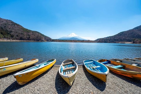 Rowing boats on shore, view across the lake to Mt Fuji volcano, Motosu Lake, Yamanashi Prefecture,