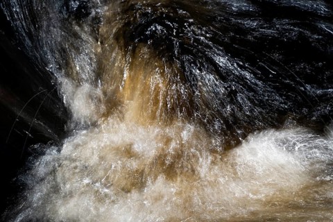 Stream flow with dark water, reflections and turbulences, long exposure, Sweden