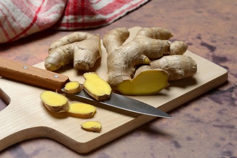 Ginger, ginger root cut with ginger slices on wooden boards