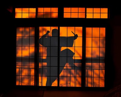 Shadow of a man, burglar with knife, assassin, ninja, on the balcony behind sliding shoji doors in