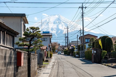 Street scene in a residential area, residential buildings and power lines, view of Mt. Fuji,