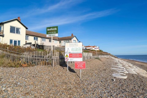 For Sale estate agent signs outside houses at risk of coastal erosion, Thorpeness, Suffolk, North