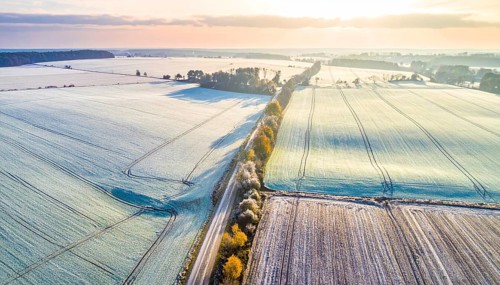 Bird Eye Perspective of Frost Covered Farmland. Seasonal Agricultural Scenery, winter and autumn