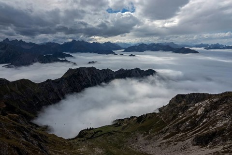 View from the Nebelhorn summit to mountains of the Allgäu Alps, mountains rising from fog in the