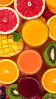 Fresh fruit juices in glasses, surrounded by colorful fruits, showcasing healthy drinking and