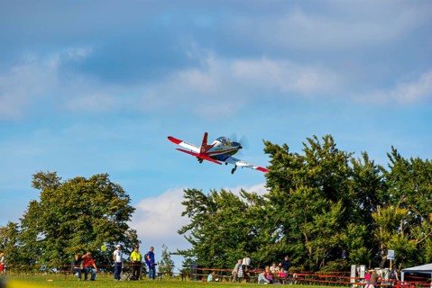 An RC model of a Pilatus PC-21 with advertising for the Swiss watch brand Breitling during a flight