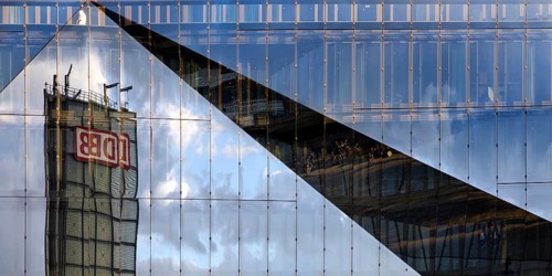 Cube Berlin, cube-shaped office building with folded glass façade reflecting the surroundings,
