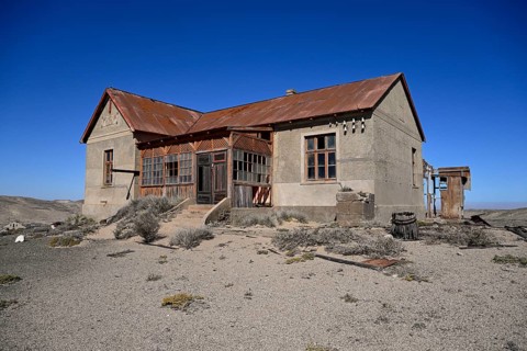 Dilapidated building in the desert sand, Pomona, restricted diamond area, near Lüderitz, Karas
