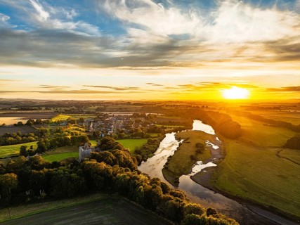 Sunset over Norham Castle and River Tweed from a drone, Norham, Northumberland, England, United