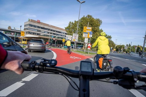Riding a bike in a bike lane, marked in red to attract the attention of motorists, between 2 lanes,