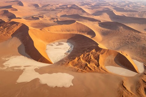 Sand dunes and dry pans in the Namib Desert. In the evening. Aerial view. Namib-Naukluft Park,