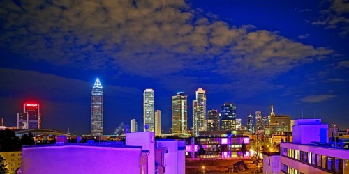 Rooftop day with colourfully illuminated houses for a techno party on the roof with a view of the
