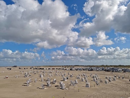 North Sea beach, car park, blue sky, white clouds, summer, sun, sand, beach chairs, on the edge of