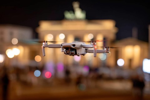Ein Fernpilot steuert sein Quadrocopter, Drohne illegal über dichtbesiedeltes Stadtgebiet an einem