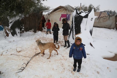 Displaced Syrian families and children living in refugee camps during harsh winter conditions,