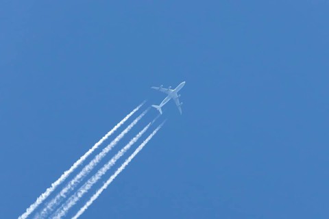 Airbus A340-300 jet aircraft of Lufthansa airlines in flight in a blue sky with vapour trails or