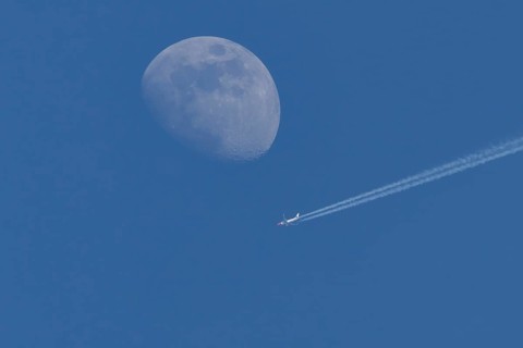 Boeing 737 jet passenger aircraft of Norweign Air with a vapour trial or contrail behind flying in