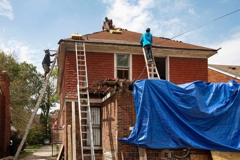 Detroit, Michigan - Workers re-roof a house they are remodeling in the Morningside neighborhood