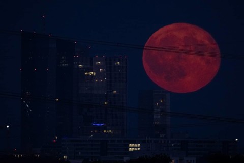The full moon passes over the Frankfurt banking skyline, Frankfurt am Main, Hesse, Germany