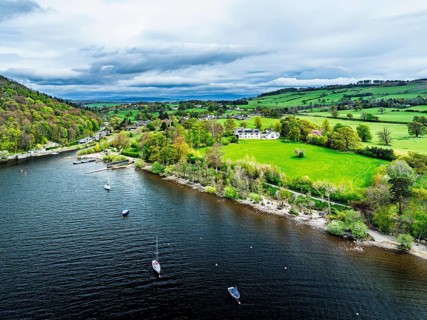 Farms and mountains over Ullswater Lake from drone, Pooley Bridge, Lake District National Park,