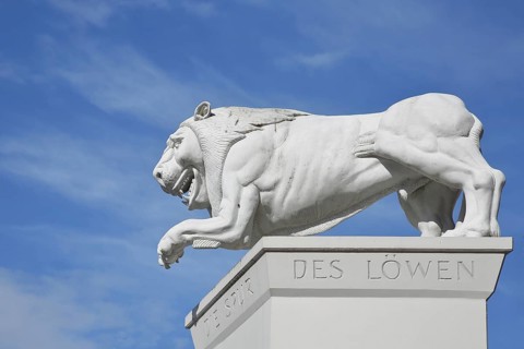 White Lion Monument by Peter Lenk 1996 with inscription Die Spur des Löwen and monument to the city