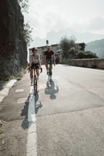 Woman and man riding racing bikes in Italy on Lake Garda