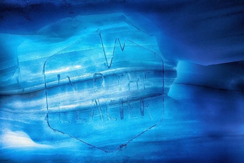 Faded logo with inscription, engraving in melting ice, Into the Glacier, ice tunnel, glacier cave,