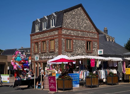 Weekly market with regional products, behind it co-operative bank, savings bank Crédit Agricole,