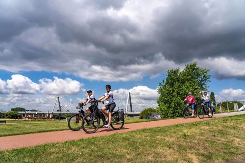 Cycle path in the Neulandpark in Leverkusen on the Rhine, in the background the new Rhine bridge of