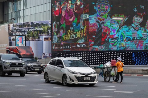 Street crossing woman with cookshop, Bangkok, Thailand