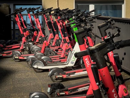 Many rental e-scooters parked on a pavement in Wuppertal, Germany