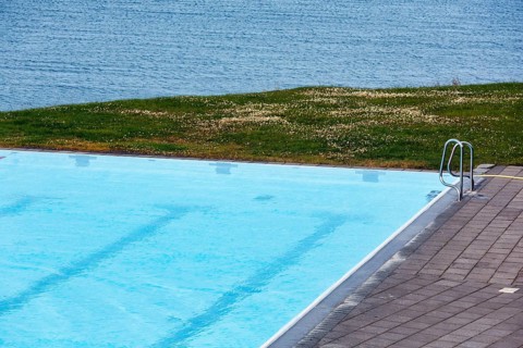 View from above of swimming pool by the sea, thermal bath, heated outdoor pool in Hofsos at the
