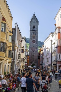 Old town, colourful houses in the main street, Zwölferturm tower at the back, old town, Sterzing,