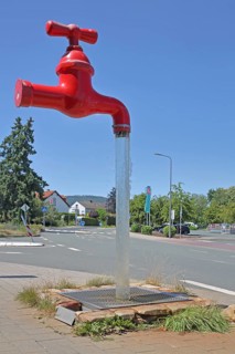 Red free-standing tap with water jet, fountain, modern art, sculpture, dummy, figure, pipeline,