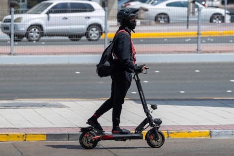 Man with electric scooter, Abu Dhabi, United Arab Emirates
