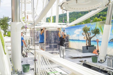 People aligning a cabin in a Ferris wheel in front of a landscape scenery, Ferris wheel