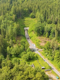 A wooded area with a railway line and a tunnel in the middle, construction of the Hermann Hesse